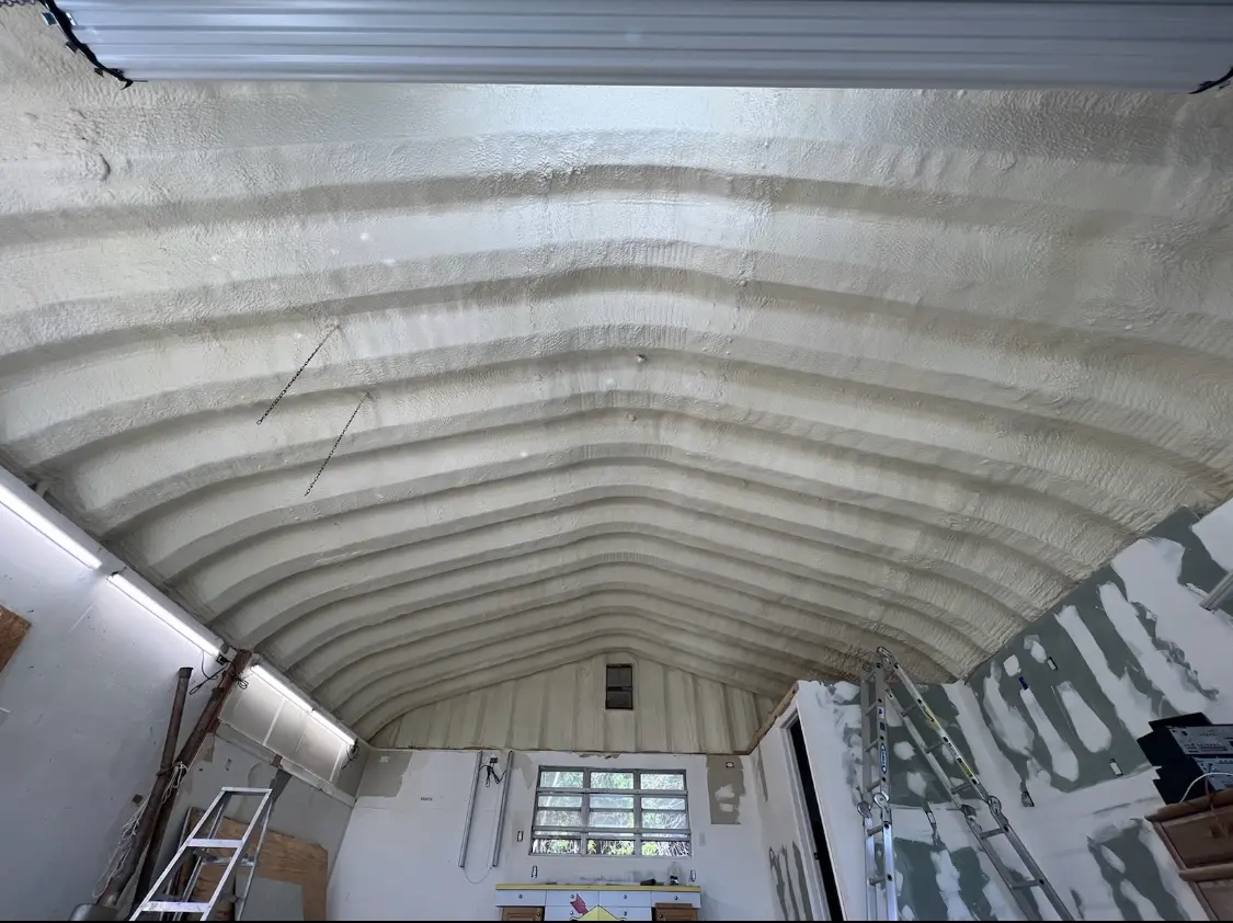 Spray polyurethane foam applied to the underside of a metal roof deck in Alma